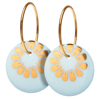 Øreringe med vedhæng af porcelæn, indfarvet i delikat lys blå, med SCHERNING's klassiske BLOOM dekoration i blank guld. Forgyldt sterling sølv · Creol dia. 18 mm Vedhæng: håndlavet porcelæn · Dia. 18 mm Pris pr. par: 399 DKK CLOUD/GOLD · Varenr: BM17-3812G