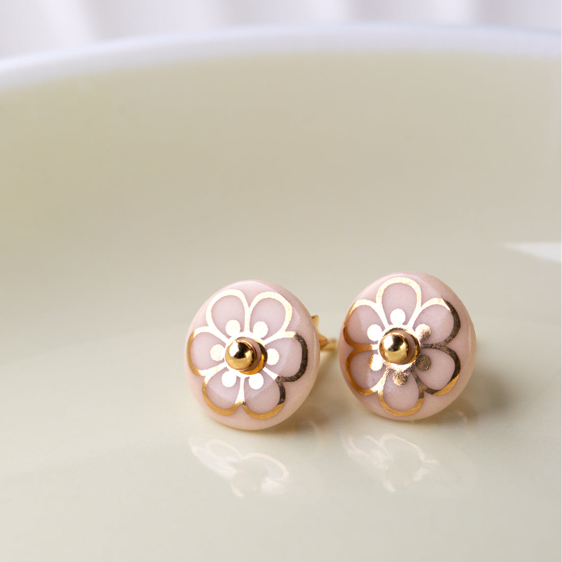 Ørestikkere af porcelæn, indfarvet i fin sart rosa, med den søde FLORA dekoration i blank guld.